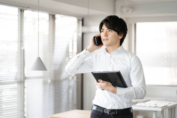 istock Asian man making phone calls in the office 1390194764