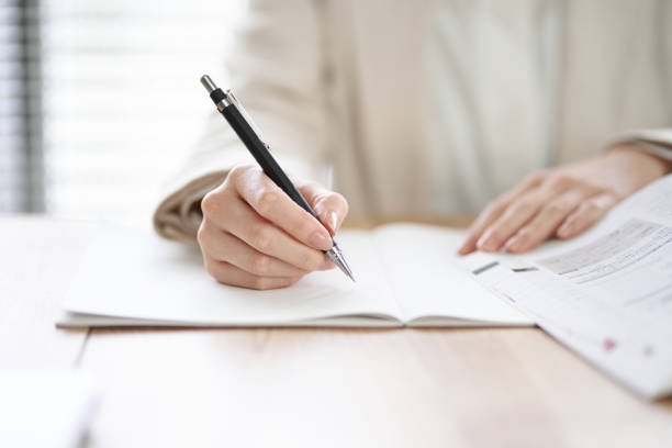 hands of an asian woman studying in a coworking space - exam imagens e fotografias de stock