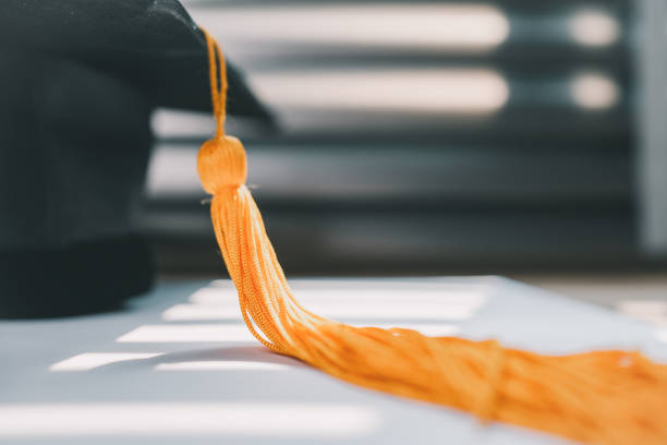 lack graduation cap university level and a notebook on a wooden table, graduation concept