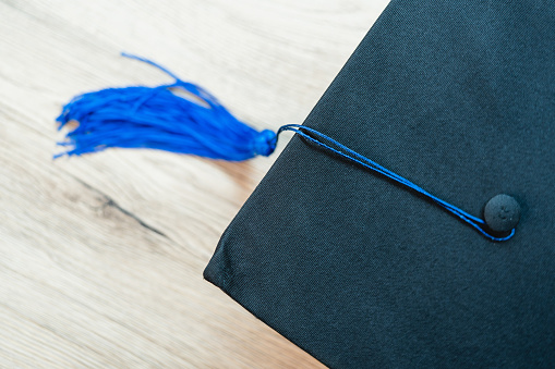 Black graduation cap University level, placed on a wooden table, concept, graduation