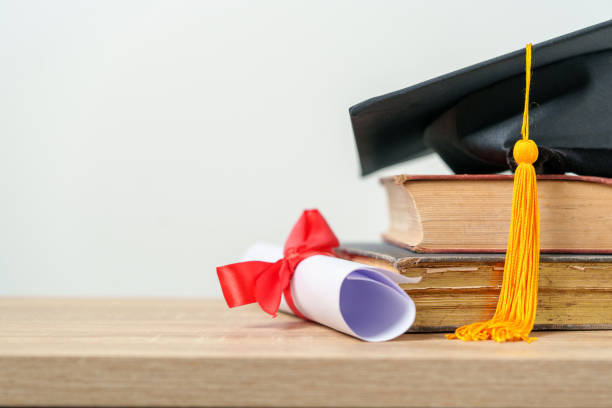 istock single black graduate cap on old books on the table background 1390207471