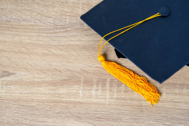 istock Black graduation cap University level, placed on a wooden table, concept, graduation 1390207514