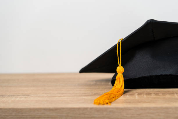 istock Black graduation cap University level, placed on a wooden table, concept, graduation 1390207568