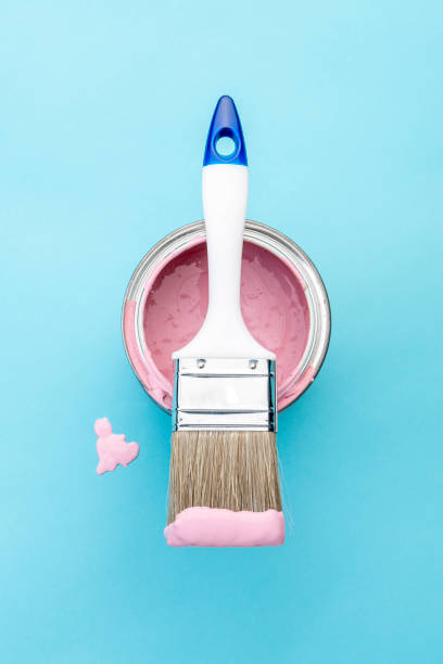 istock Brush on open can of pink paint on blue pastel background 1390208588