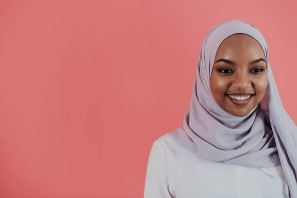 istock Videographer in digital studio recording video on professional camera by shooting female Muslim woman wearing hijab scarf plastic pink background 1390209309