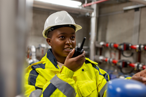 Female worker using walkie talkie to communicate.