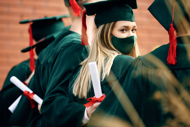 istock University student and her classmates on their graduation day during coronavirus pandemic. 1390211655
