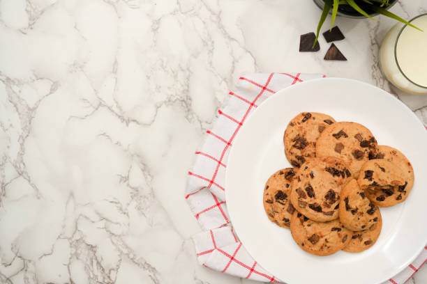 istock Yummy chocolate chip soft cookies in a white plate on white marble background. 1390213647
