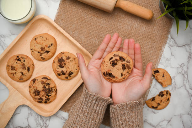 istock Top view, A chocolate chip cookie in a woman hands 1390213651