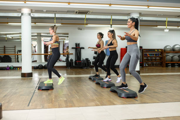 istock Cheerful sportswomen exercising on steppers 1390215930