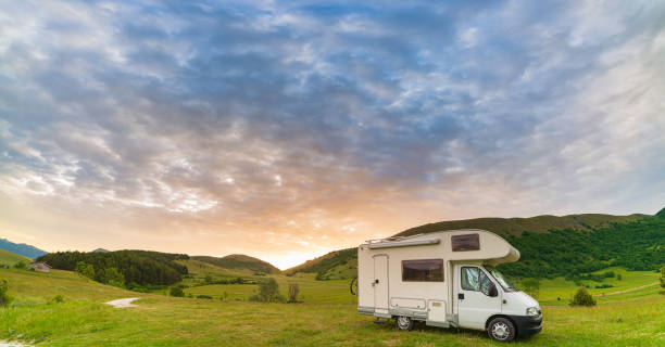 istock Sunset dramatic sky over camper van in Montelago highlands, Marche, Italy. Epic clouds above unique hills and mountains landscape, alternative vanlife vacation concept. 1390217713