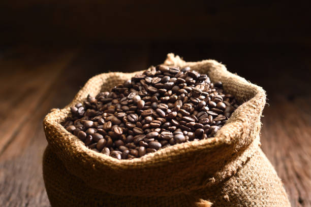 istock Roasted coffee beans in burlap sack. Freshly roasted strong aromatic dark brown coffee beans in burlap sack 1390217883