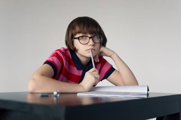 istock A schoolgirl with glasses is doing her homework 1390218261