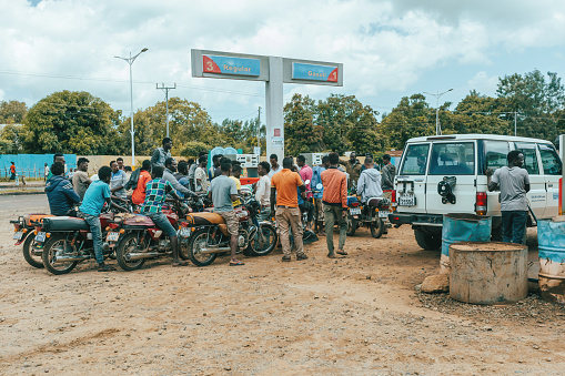 Jinka, Southern Nations Ethiopia - May 16, 2019: Young Ethiopian men, bikers, waiting at a gas station for refueling. City Jinka, Southern Nations Ethiopia, Africa