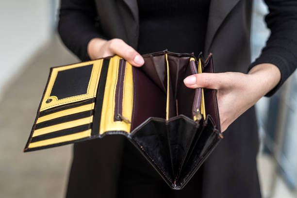 istock stylish lady in a black classic suit holds an open empty wallet in her gentle hands. 1390219154