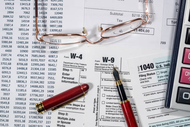 istock many us tax form 1040 w4 w9 on office desk. financial documents 1390220655