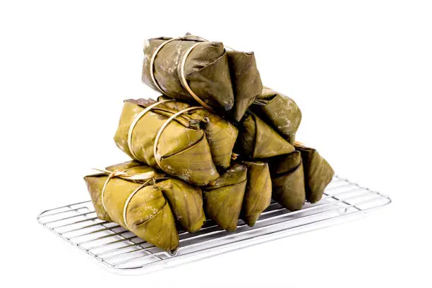 Photo of Pile of bundled boiled rice is stacked isolated on white background, Thai dessert.