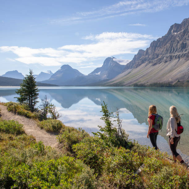 madre e figlia adolescente camminano lungo la riva del lago di montagna - bow lake foto e immagini stock