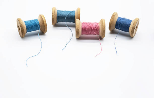istock Colorful threads for sewing. Different threads on wooden vintage reels. 1390226268