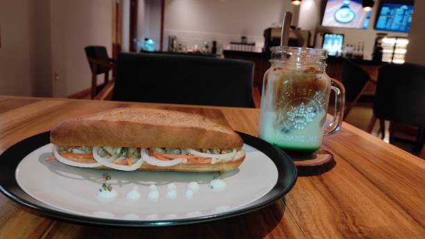 Hotdogs on a plate with iced coffee latte on a cafe table