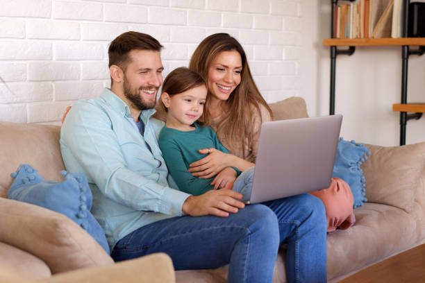 istock Smiling family relaxing at home and using laptop together 1390227643
