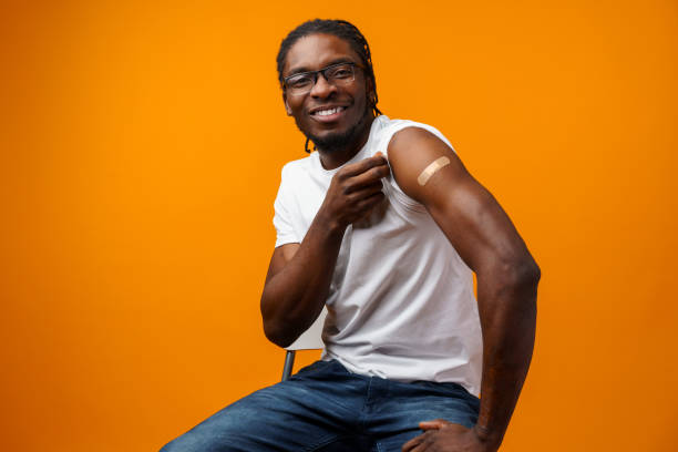 istock Young black man got vaccinated from coronavirus against yellow background 1390229736