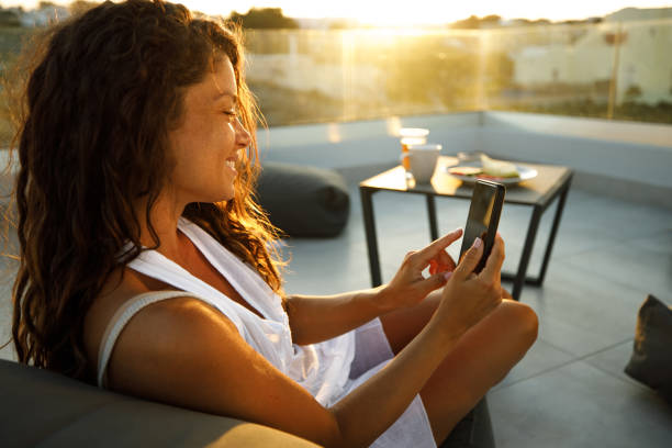 istock Happy woman using mobile phone on a terrace. 1390229881