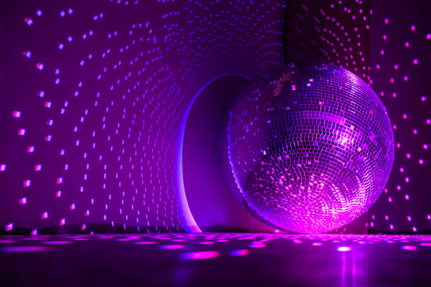 istock Disco ball reflecting purple light in a dark hall. Disco symbol. 1390232588