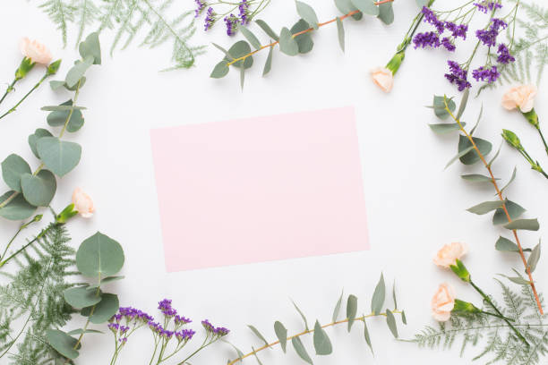 istock Flowers composition. Paper blank, carnation flowers, eucalyptus branches on pastel  background. Flat lay, top view, copy spaceFlat lay stiil life. 1390233054