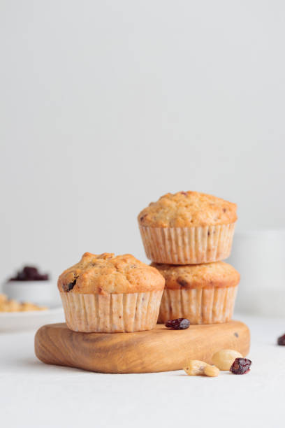 istock Muffins in a wooden plate on a white table 1390233899