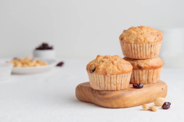 istock Muffins in a wooden plate on a white table 1390233917
