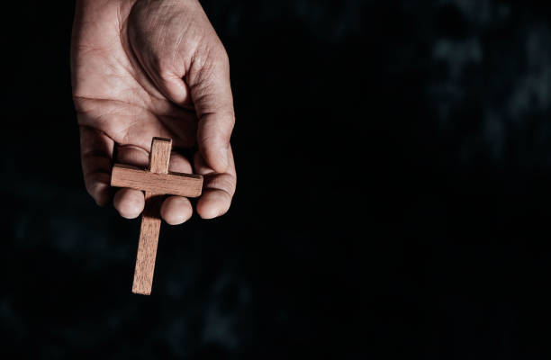 istock man holds a wooden cross in his hand 1390237770
