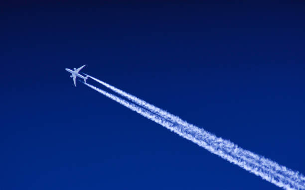 twin engine passenger jet at high altitude - rasto de fumo de avião imagens e fotografias de stock