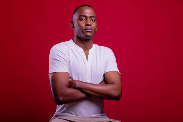 istock Confident young man. Black man portrait in red background. 1390241288
