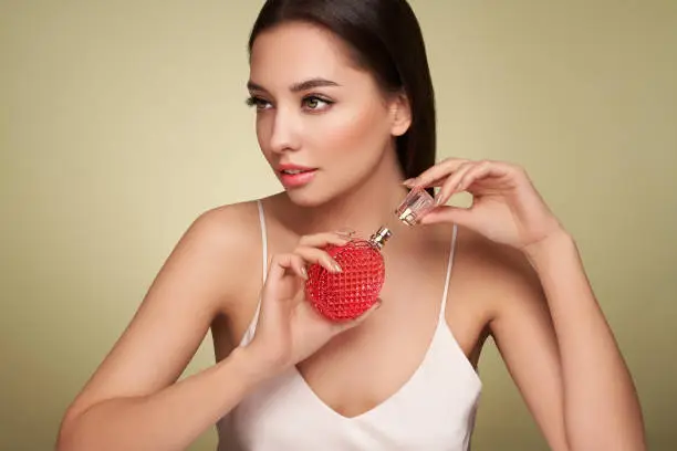 Photo of Young beautiful woman with a bottle of perfume