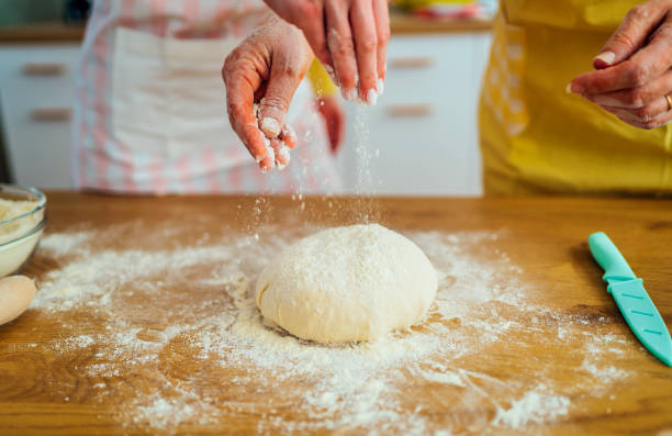 istock Mother and daughter preparing dough 1390242609