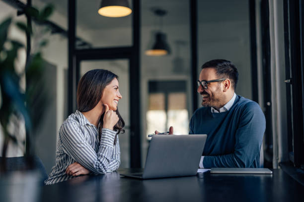 istock Businesswoman and man, elegantly dressed, looking at each other. 1390242643