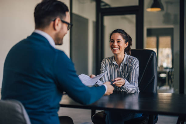 istock Business people, sharing documents, smiling at each other. 1390242652