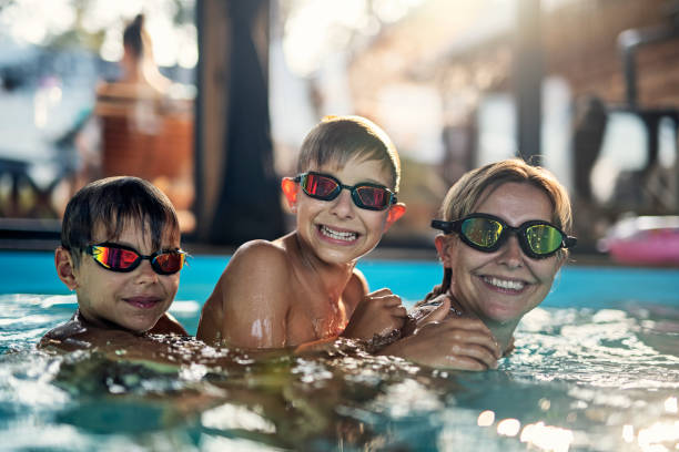istock Mother and sons playing in indoors swimming pool 1390243605