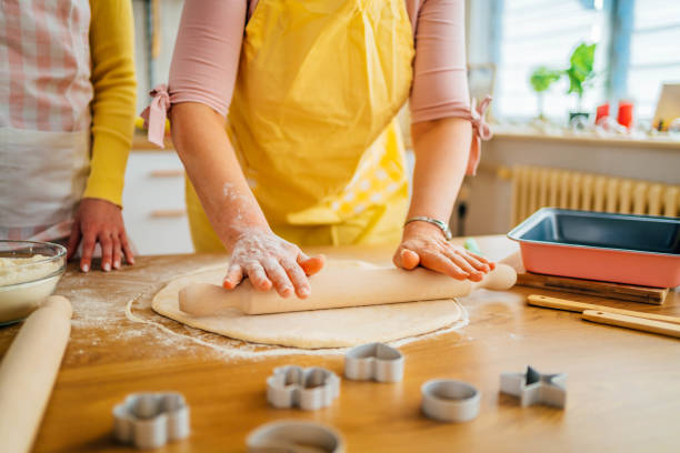 istock Mother and daughter kneading dough 1390243664