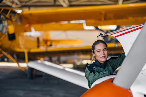 Picture of happy adult woman, learning how to fly a plane.