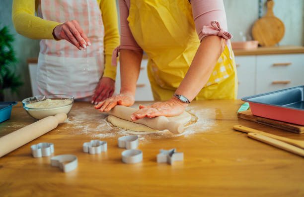 istock Mother and daughter kneading dough 1390245245