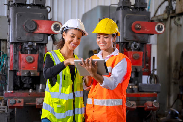 istock Blue collar worker with co worker at factory. 1390245657