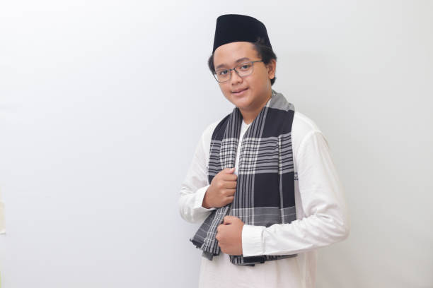 istock Asian muslim man standing with cool pose and holding his sarong 1390250058