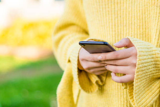 istock Young woman using a smartphone in the park 1390252650