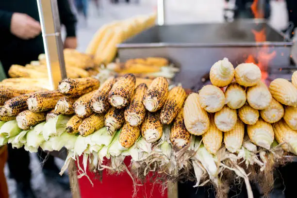 Photo of Famous and cheapest street foods in Istanbul Boiled and Grilled Corn. Smoked grilled roasted corn in cart