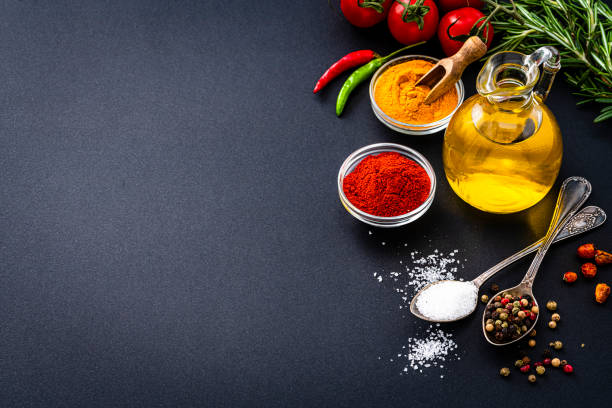 istock Salt, pepper, olive oil and spices on black background. Copy space 1390257014