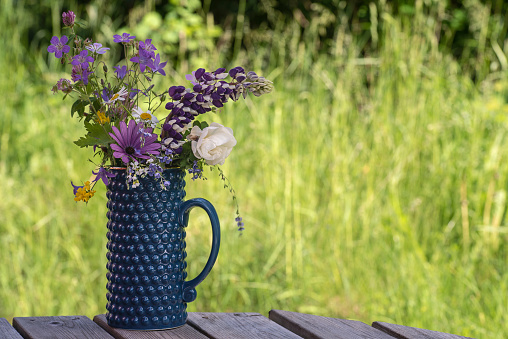 Flower in blue vase with nature's wild flowers picked in June in Sweden