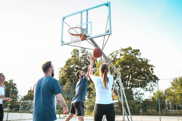 istock Couples Enjoying Basketball Match On Court 1390258722
