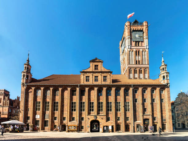 Torun, Poland - March 28, 2022: Beautiful gothic building of a medieval City Hall in Torun, Poland. Historical street of an ancient european city. Magnificent clock tower